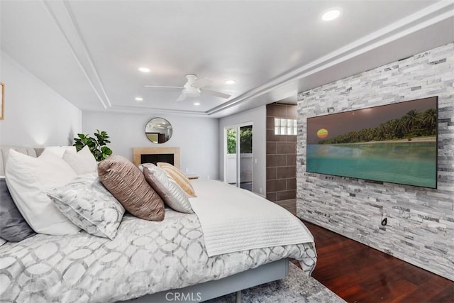 bedroom with a ceiling fan, recessed lighting, a tray ceiling, and wood finished floors