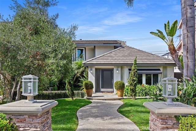 view of front of home with a front yard and stucco siding