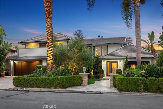 view of front of home featuring driveway, an attached garage, and stucco siding