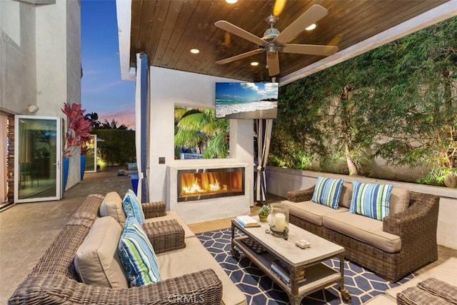 view of patio / terrace featuring ceiling fan and an outdoor living space with a fireplace