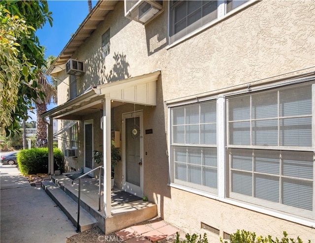 doorway to property featuring cooling unit and an AC wall unit