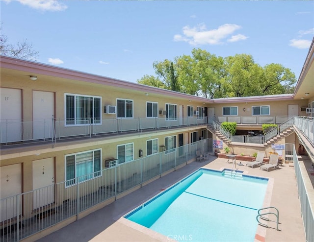 view of swimming pool with a patio and an AC wall unit