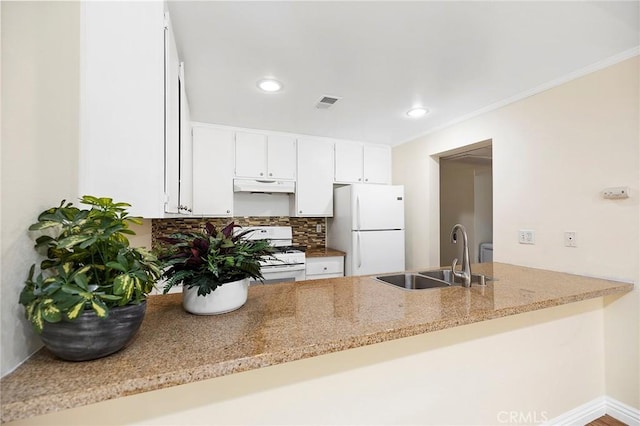 kitchen featuring white appliances, sink, light stone counters, kitchen peninsula, and tasteful backsplash