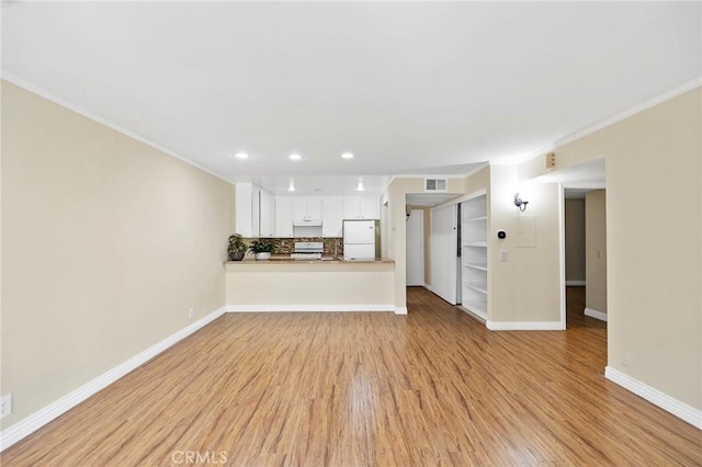 unfurnished living room with light hardwood / wood-style flooring and crown molding