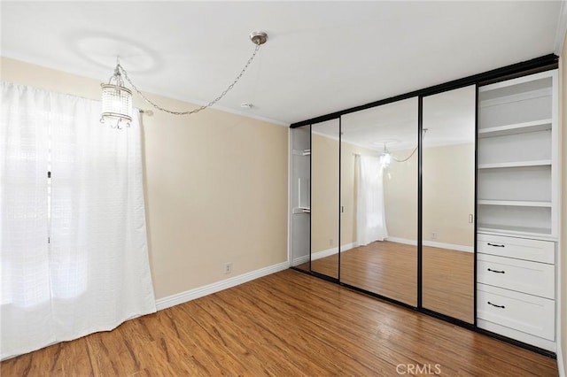 unfurnished bedroom with hardwood / wood-style flooring and an inviting chandelier