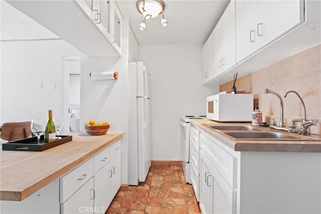 kitchen with white cabinetry, sink, and white appliances