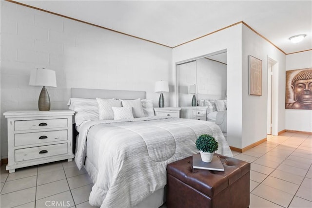 bedroom featuring a closet, light tile patterned flooring, and crown molding