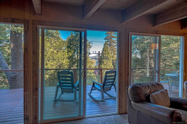 sunroom featuring lofted ceiling with beams, wooden ceiling, and a wealth of natural light