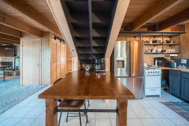 kitchen with stainless steel fridge, white range oven, wooden ceiling, and light tile patterned flooring