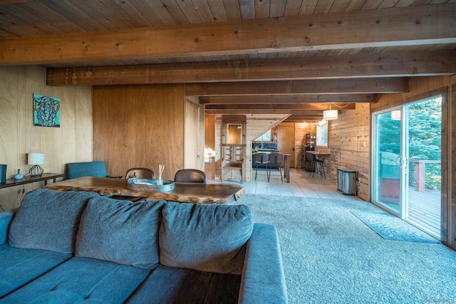 living room with wood walls, carpet floors, wood ceiling, and beam ceiling