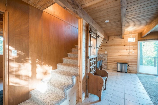 interior space featuring wood walls, beam ceiling, wooden ceiling, and tile patterned floors