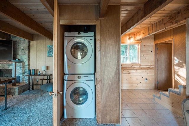 washroom with stacked washer and clothes dryer, wooden walls, wooden ceiling, and light tile patterned floors