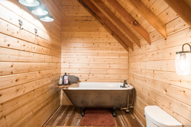 bathroom with lofted ceiling with beams, a tub to relax in, hardwood / wood-style flooring, and wood walls