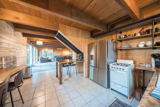 kitchen featuring stainless steel fridge with ice dispenser, wooden walls, wood ceiling, and white range with gas cooktop