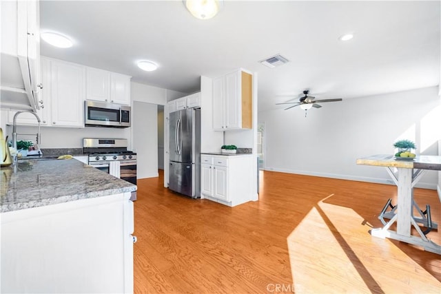 kitchen with sink, light hardwood / wood-style flooring, ceiling fan, appliances with stainless steel finishes, and white cabinetry