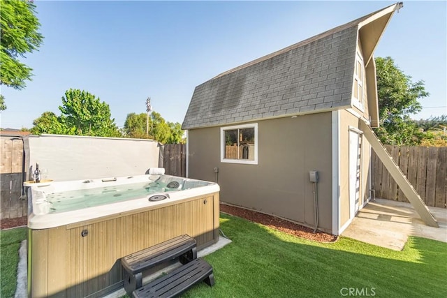 exterior space featuring a yard and a hot tub