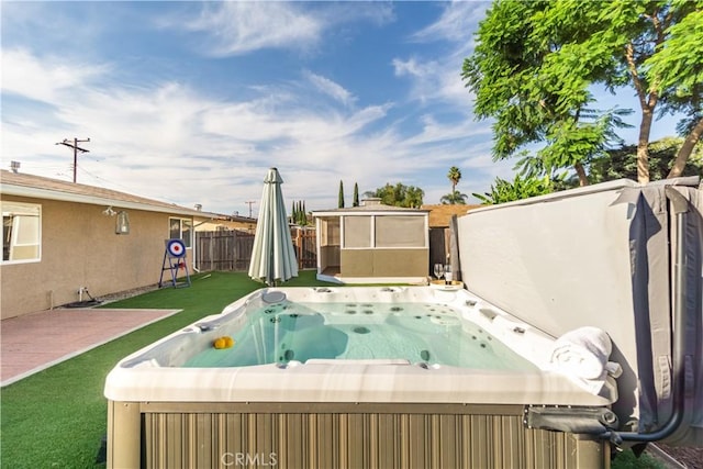 view of pool featuring a yard and a hot tub