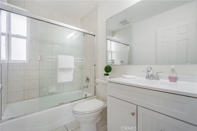 full bathroom featuring enclosed tub / shower combo, toilet, and vanity