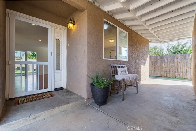 view of exterior entry with a patio