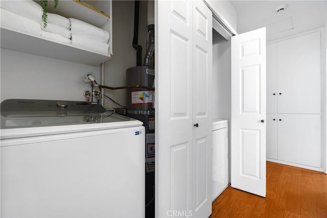 washroom with washer / clothes dryer and light hardwood / wood-style flooring