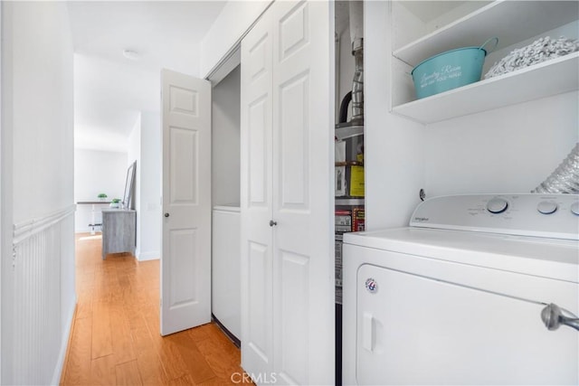 clothes washing area with light wood-type flooring and washer / clothes dryer