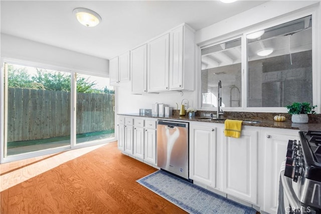 kitchen featuring white cabinets, appliances with stainless steel finishes, light hardwood / wood-style floors, and sink