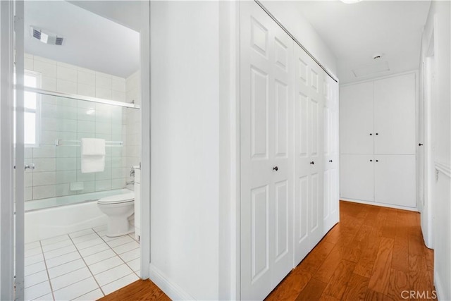 corridor featuring wood finished floors and visible vents