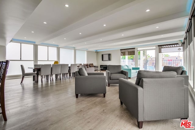 living room with beamed ceiling and light hardwood / wood-style flooring