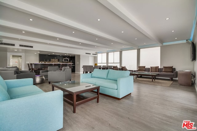 living room with beamed ceiling and light hardwood / wood-style flooring