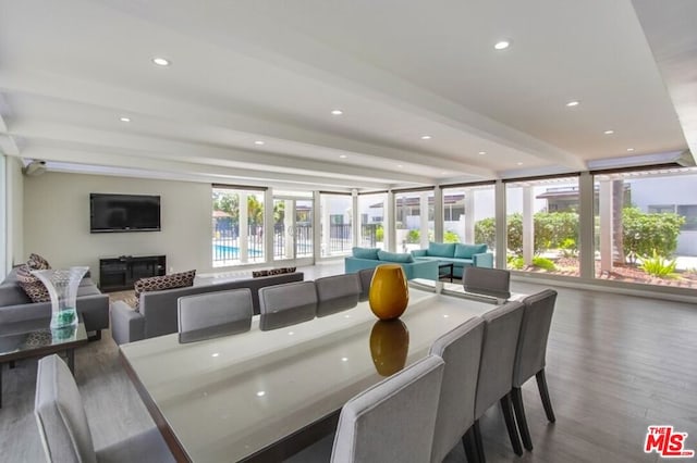 dining space with hardwood / wood-style floors and beam ceiling