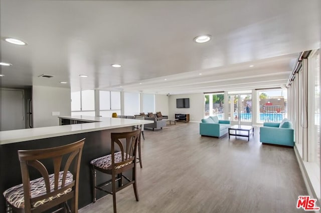 kitchen with a kitchen breakfast bar and hardwood / wood-style flooring