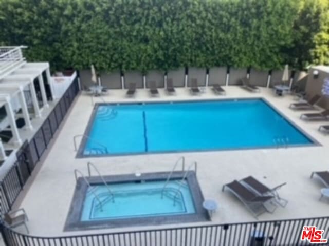 view of pool featuring a patio and a hot tub