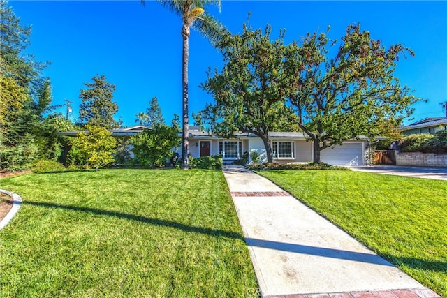 ranch-style home featuring a garage and a front lawn