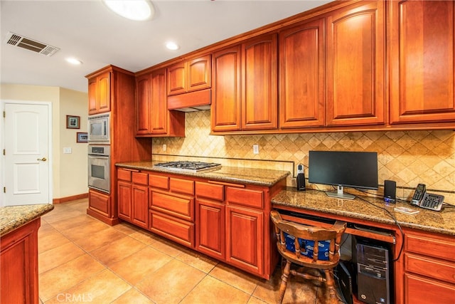 kitchen with light stone counters, stainless steel appliances, tasteful backsplash, and light tile patterned floors