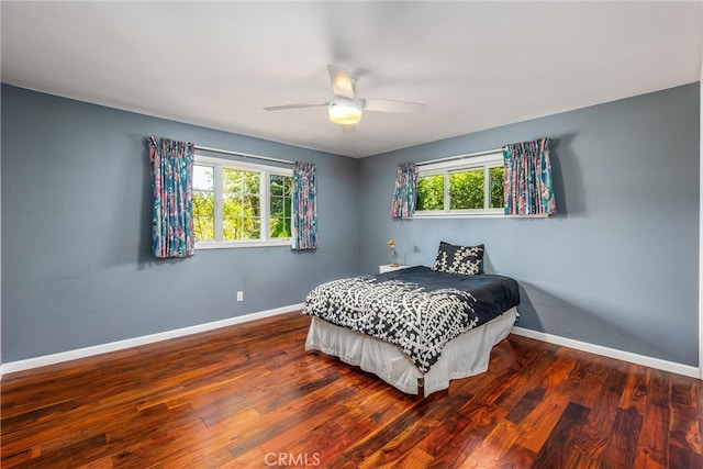 bedroom with multiple windows, hardwood / wood-style flooring, and ceiling fan