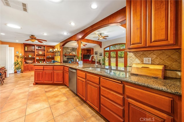 kitchen with kitchen peninsula, light tile patterned floors, light stone countertops, dishwasher, and sink