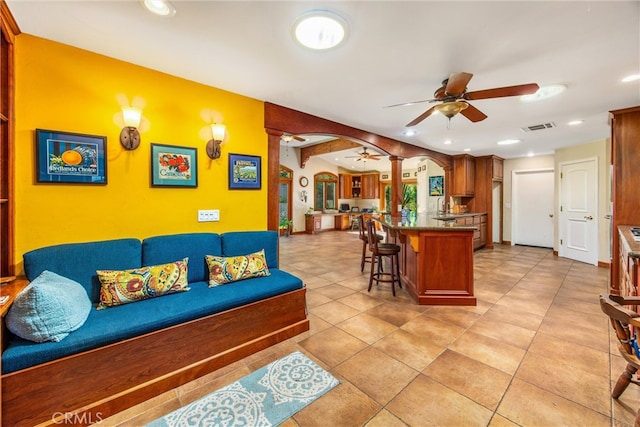 tiled living room with sink and ceiling fan