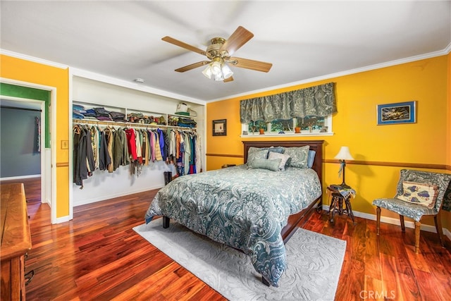 bedroom with a closet, hardwood / wood-style flooring, crown molding, and ceiling fan