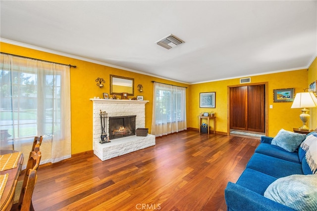 living room with crown molding, hardwood / wood-style flooring, plenty of natural light, and a fireplace