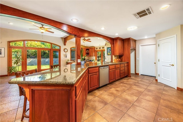 kitchen featuring a kitchen breakfast bar, kitchen peninsula, dishwasher, and sink