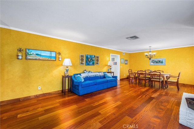 living room with crown molding, a notable chandelier, and hardwood / wood-style flooring