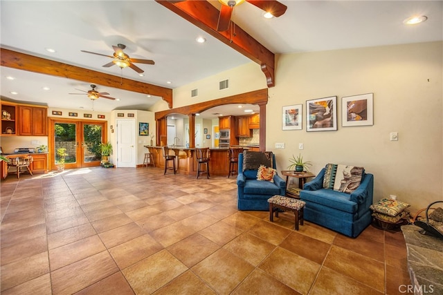 living room with french doors, ceiling fan, and vaulted ceiling with beams