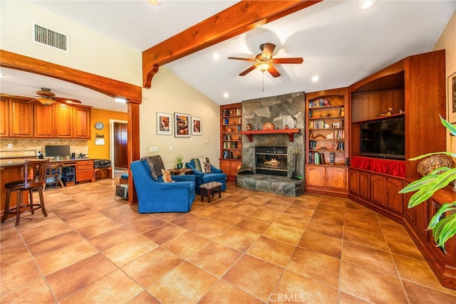 living room featuring ceiling fan, lofted ceiling with beams, a fireplace, and built in shelves