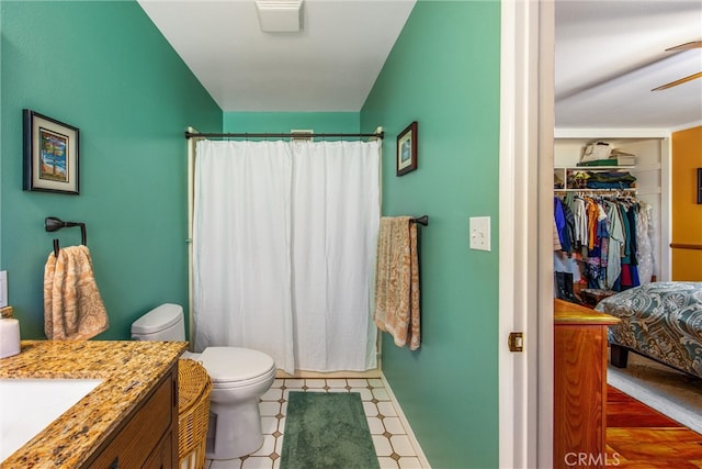 bathroom with toilet, ceiling fan, walk in shower, vanity, and hardwood / wood-style flooring