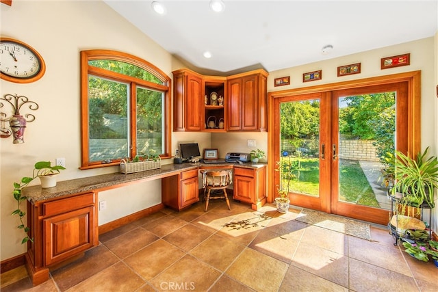 home office featuring built in desk, a healthy amount of sunlight, and french doors