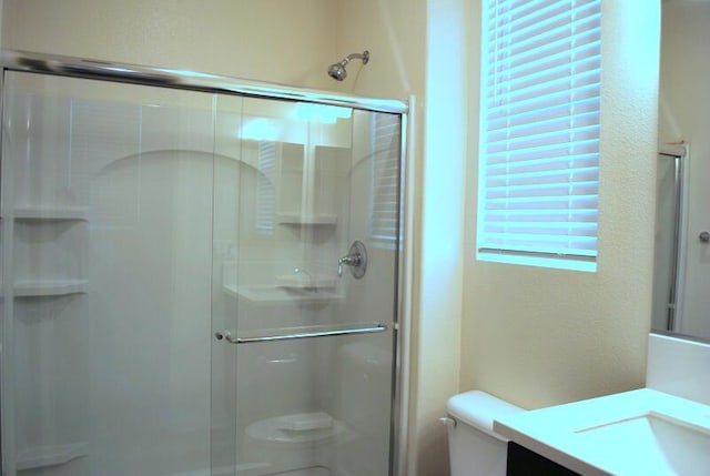 bathroom featuring vanity, toilet, and walk in shower