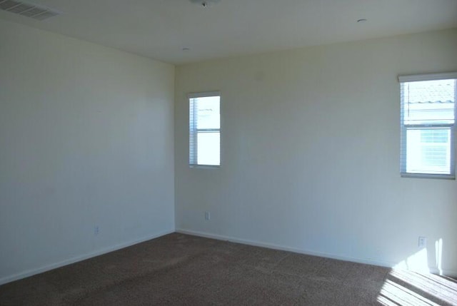 empty room with dark colored carpet