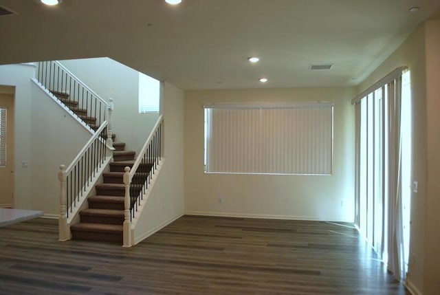 staircase with plenty of natural light and wood-type flooring