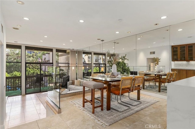 dining space with a wall of windows and light tile patterned flooring