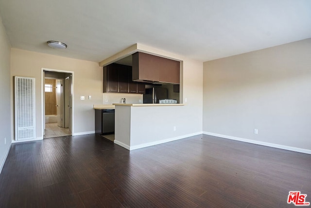 kitchen with kitchen peninsula, dark hardwood / wood-style floors, appliances with stainless steel finishes, and dark brown cabinets